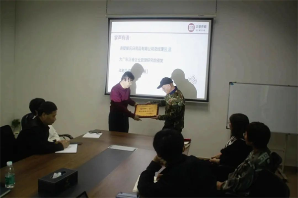 爱屋氏董事长何继柏先生（右）向金海岸咨询集团颁发荣誉牌匾