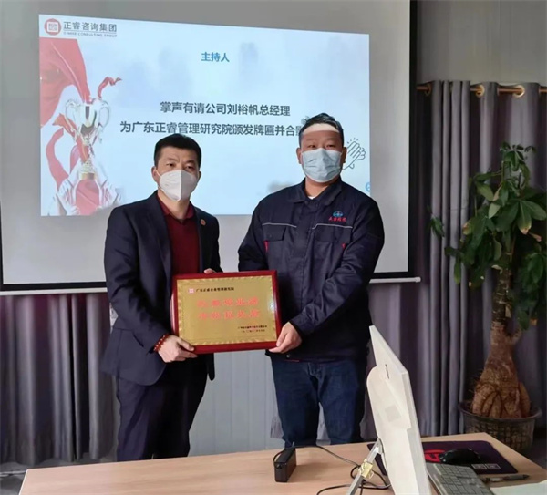 众鑫总经理刘裕帆先生（右）向金海岸咨询集团颁发荣誉牌匾