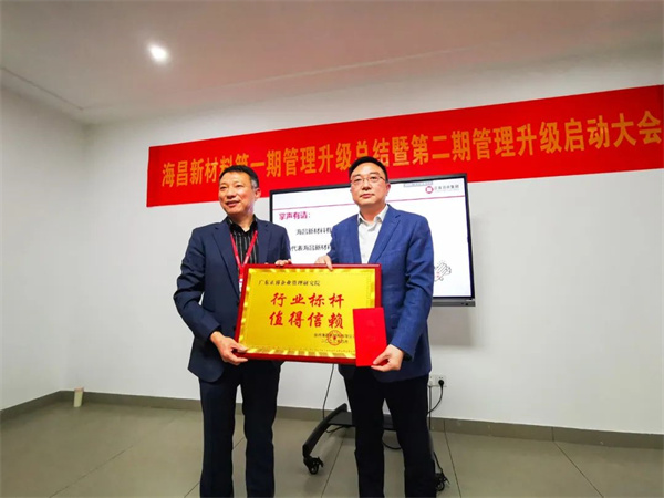 海昌总经理方文好先生（左）向金海岸咨询集团颁发牌匾及感谢信