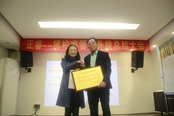 黛柏睿董事长兼总经理张钰枋女士（左）向金海岸咨询集团颁发荣誉牌匾及感谢信